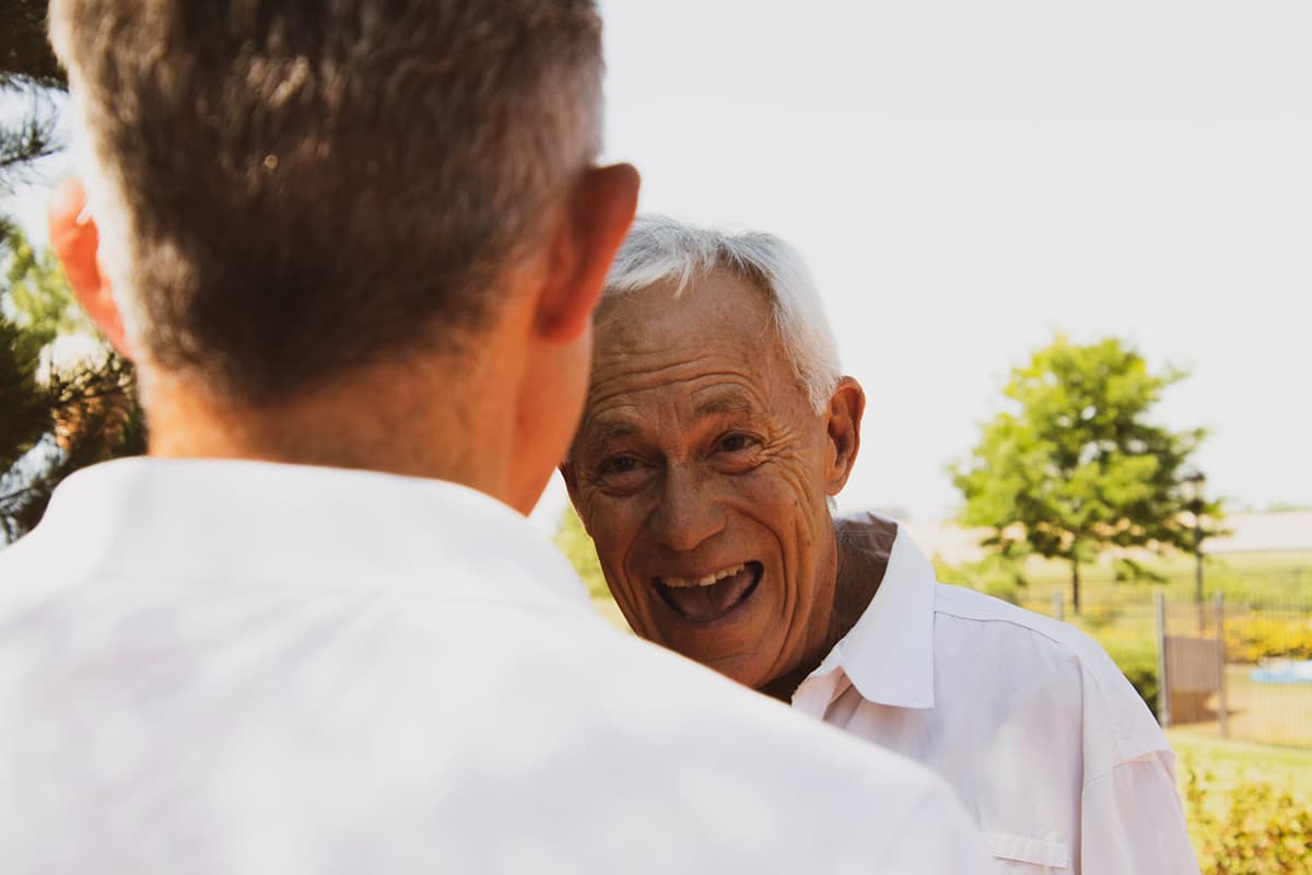 Man wearing a hearing aid speaking with a younger relative