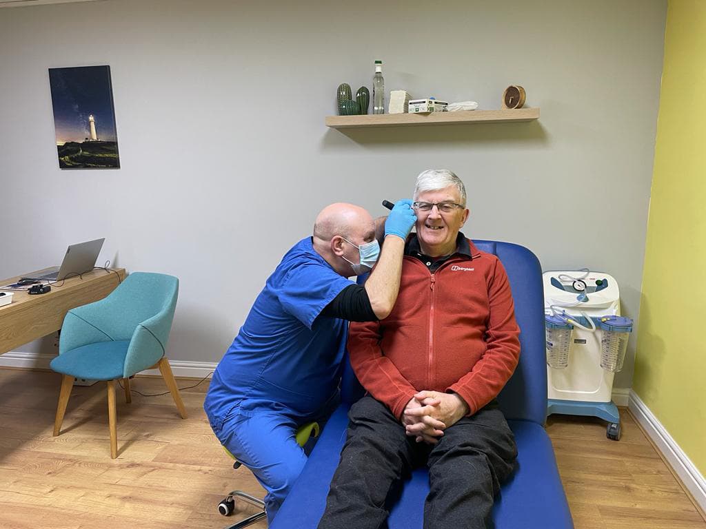 Smiling patient having their ear examined